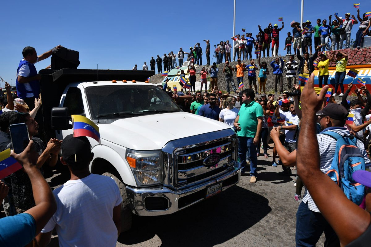 La gente aplaude cuando camiones con ayuda humanitaria a Venezuela se acercan a la frontera entre Brasil y Venezuela en Pacaraima, estado de Roraima, Brasil (AFP).