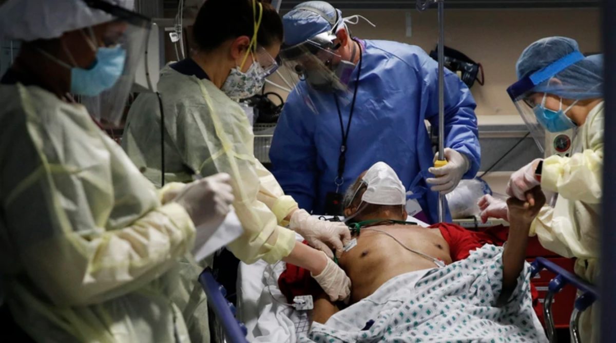 El Dr. Anthony Leno, Director de Medicina de Emergencia, centro superior, asiste a las enfermeras mientras reciben a un paciente de un hogar de ancianos que muestra síntomas de COVID-19 (AP/John Minchillo)
