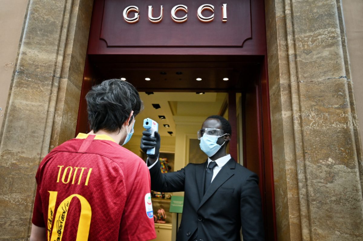 El empleado de una tienda de Gucci en Via dei Condotti, en Roma, mide la temperatura a un cliente (Foto: Alberto PIZZOLI/ AFP)