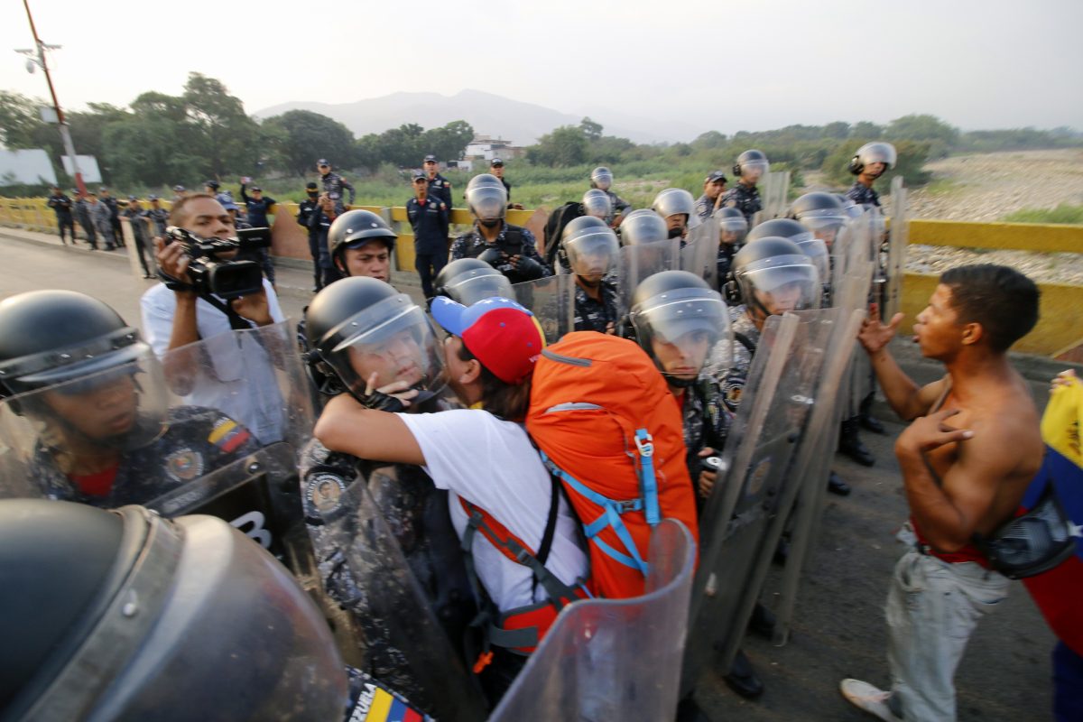 Los venezolanos se enfrentan a guardias nacionales y les piden que dejen la ayuda humanitaria en el puente Simón Bolívar, en Cúcuta, Colombia (AFP).