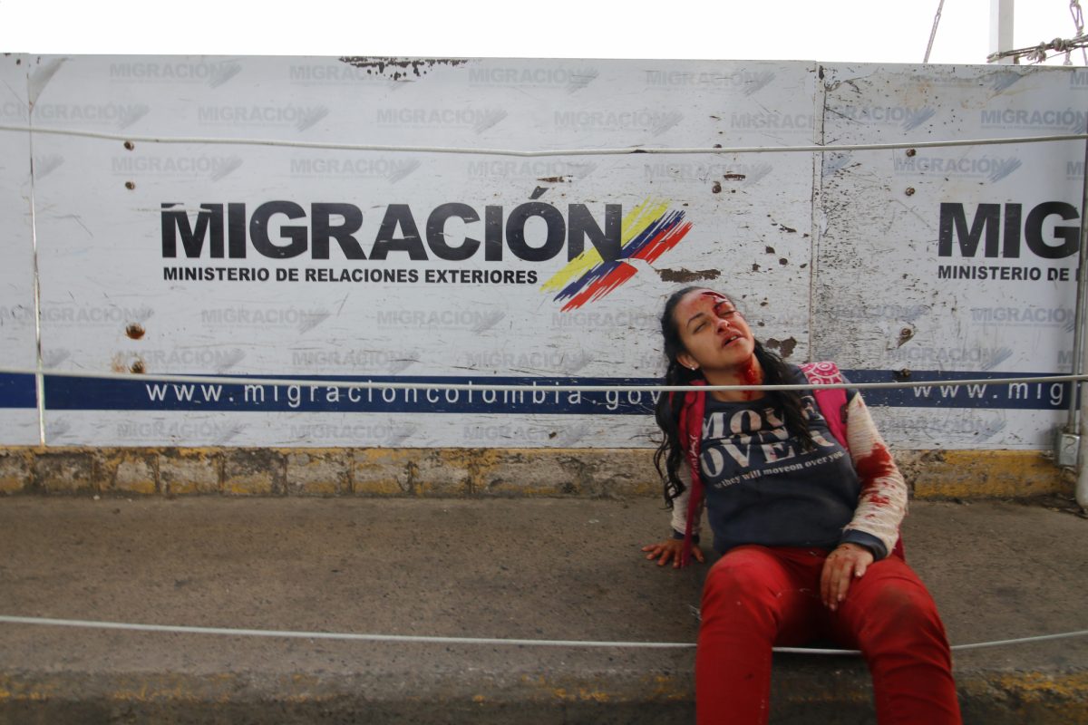 Una mujer se sienta después de lesionarse cuando dos vehículos blindados venezolanos condujeron desde el lado venezolano del Puente Internacional Simón Bolívar hacia Colombia en Cúcuta (AFP).