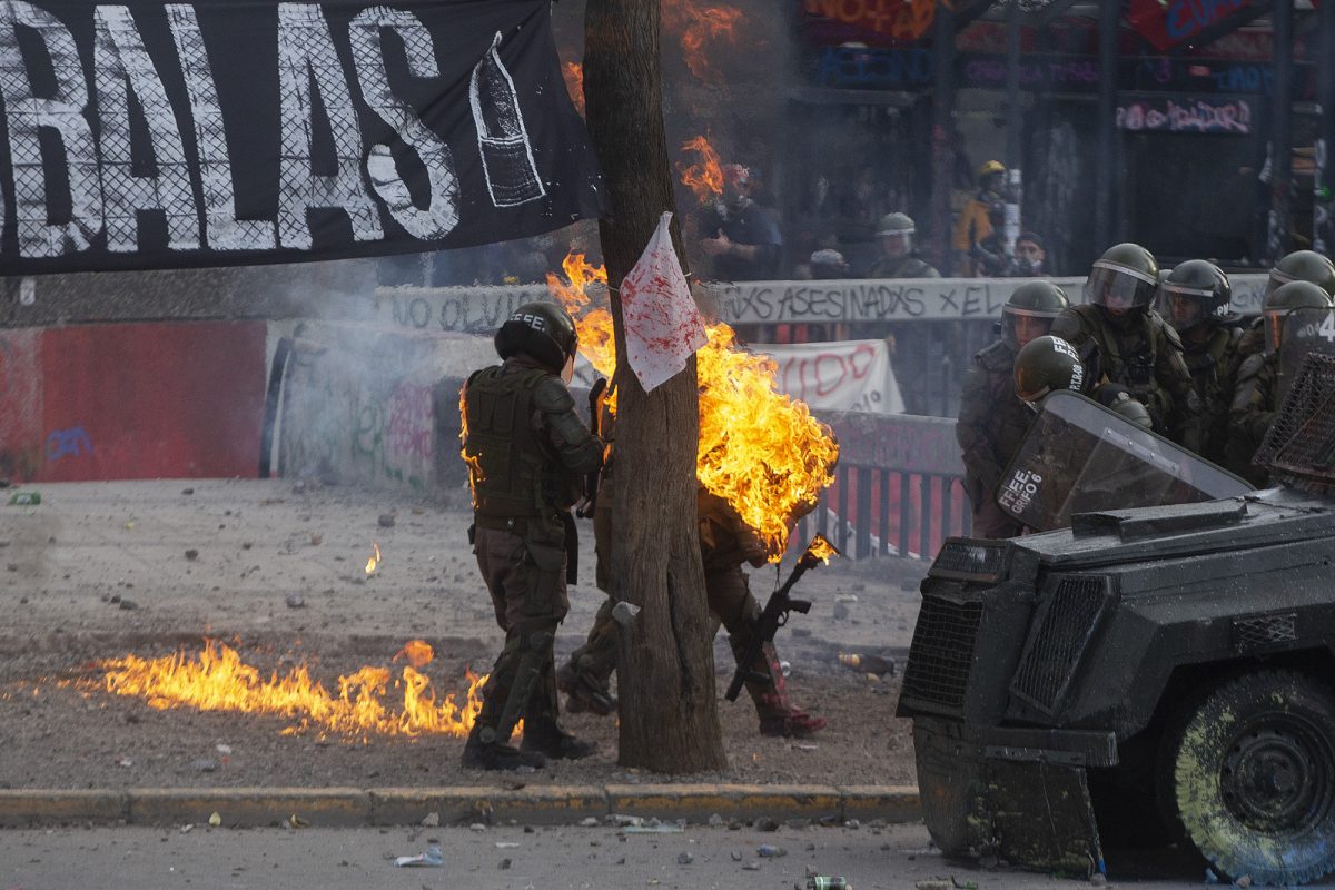 Una bomba de gasolina alcanza a la policía antidisturbios durante los enfrentamientos con manifestantes que protestan contra las políticas económicas del gobierno del presidente Sebastián Piñera, en Santiago, el 4 de noviembre de 2019. (AFP)