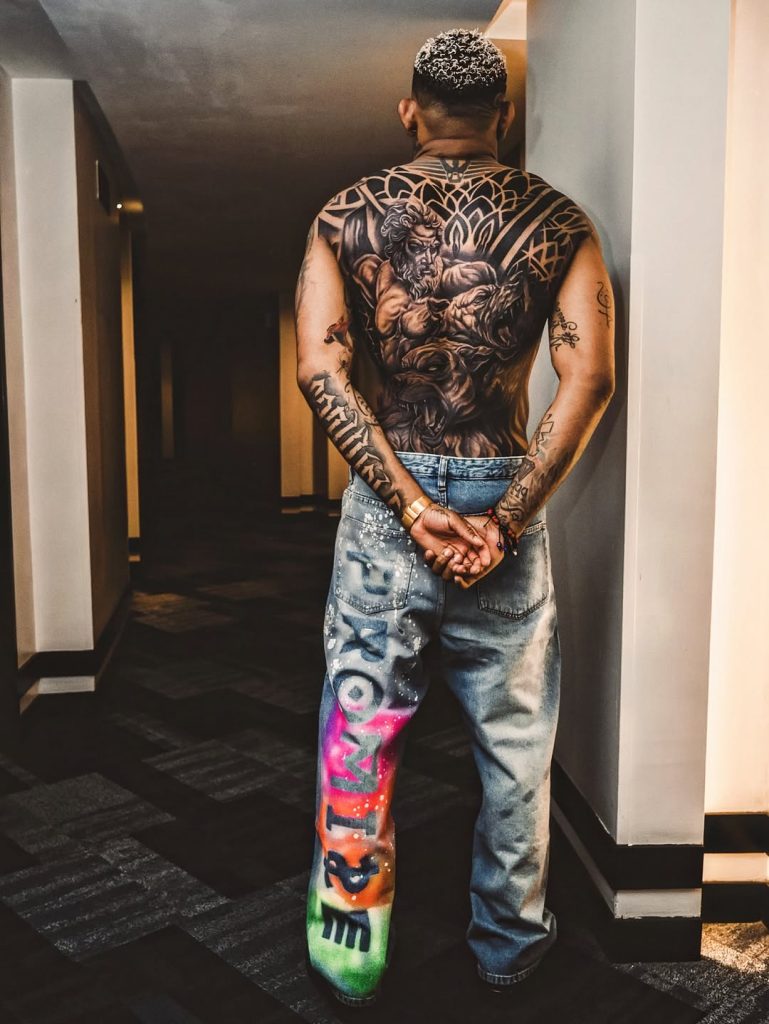 Además de los elementos mitológicos, la obra incorpora patrones de estilo tribal que recorren toda la zona lumbar y superior.